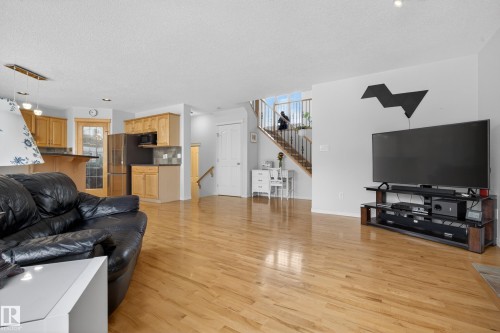 Living area featuring hardwood flooring, a staircase with wooden treads and white balusters, and recessed lighting - 1119 Rutherford Close, Edmonton, AB - Indoor Photo Showing Living Room