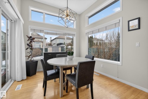 Dining area featuring hardwood floors, ample natural light from large windows, and a modern light fixture - 1119 Rutherford Close, Edmonton, AB - Indoor Photo Showing Dining Room