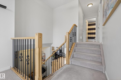 This property features a staircase with light-colored carpeting, leading to an upper landing - 1119 Rutherford Close, Edmonton, AB - Indoor Photo Showing Other Room