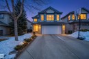 The property features a two-story exterior with a double garage, stone accents, and a concrete driveway - 1119 Rutherford Close, Edmonton, AB  - Outdoor With Facade 