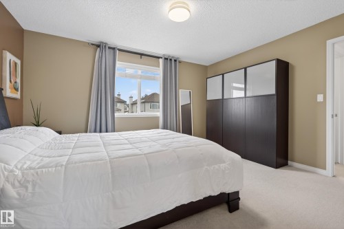 The property features a bright room with a window, light-colored carpeting, and neutral-toned walls - 1119 Rutherford Close, Edmonton, AB - Indoor Photo Showing Bedroom
