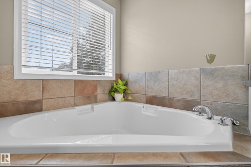 Corner bathtub with tiled surround and chrome fixtures - 1119 Rutherford Close, Edmonton, AB - Indoor Photo Showing Bathroom