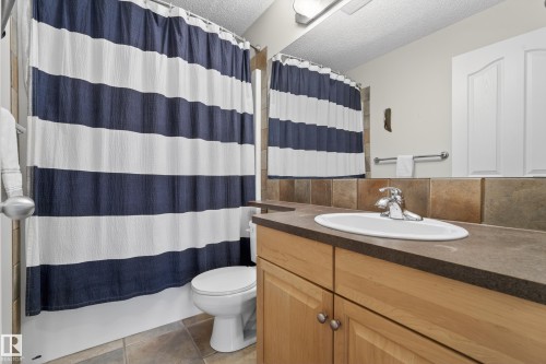 The bathroom features a vanity with a sink, a chrome faucet, and wood cabinetry - 1119 Rutherford Close, Edmonton, AB - Indoor Photo Showing Bathroom