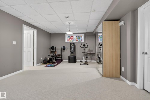 This versatile space features carpeting, grey painted walls, and a white drop ceiling - 1119 Rutherford Close, Edmonton, AB - Indoor