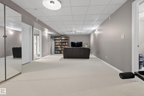 Expansive finished area featuring light-colored carpeting, recessed lighting, and wall-mounted light fixtures - 1119 Rutherford Close, Edmonton, AB - Indoor