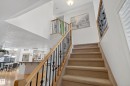 Staircase featuring carpeted steps and an ornate metal railing with a wooden handrail - 1119 Rutherford Close, Edmonton, AB  - Indoor Photo Showing Other Room 