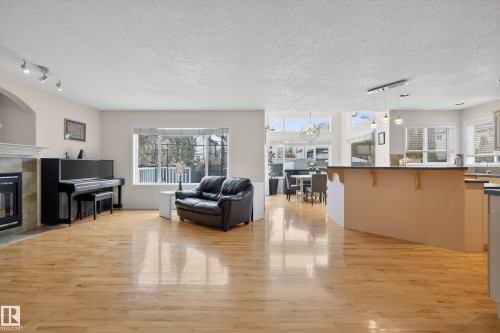 The main living area features light hardwood flooring and ample natural light from the large windows, creating a bright and inviting atmosphere - 1119 Rutherford Close, Edmonton, AB - Indoor Photo Showing Other Room With Fireplace