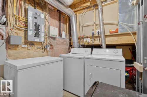 This elegantly renovated home has TWO laundry areas;     1) Full-sized side-by-side washer and dryer in lower level laundry room   AND  2) main-floor laundry off the kitchen (Midea all-in-one washer/dryer combo) - 4503 149 Avenue, Edmonton, AB - Indoor Photo Showing Laundry Room