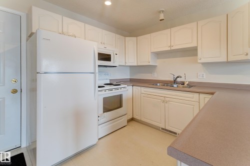 The kitchen features white cabinetry - 5 308 Jackson Road, Edmonton, AB - Indoor Photo Showing Kitchen With Double Sink