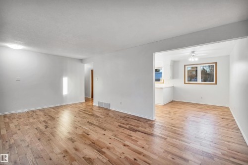 Empty room featuring light wood finished floors, ceiling fan, and a textured ceiling - 11231 41 Avenue, Edmonton, AB - Indoor Photo Showing Other Room