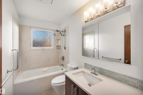 Full bathroom featuring vanity, shower / bathtub combination, and tasteful backsplash - 11231 41 Avenue, Edmonton, AB - Indoor Photo Showing Bathroom