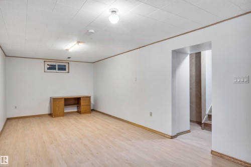 Finished below grade area with light wood finished floors and crown molding - 11231 41 Avenue, Edmonton, AB - Indoor