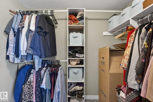 The closet features white shelving units, hanging rods, and an overhead shelf - 1873 151 Avenue, Edmonton, AB - Indoor With Storage
