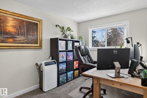 The room features light-colored walls and a window providing views of outdoor trees - 1873 151 Avenue, Edmonton, AB - Indoor Photo Showing Office