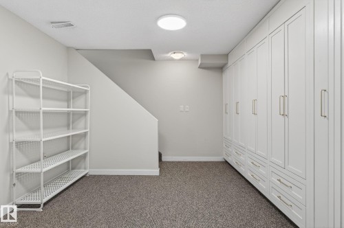 This space features extensive built-in cabinetry with paneled doors and drawers, providing generous storage - 1873 151 Avenue, Edmonton, AB - Indoor Photo Showing Other Room