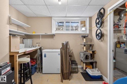 This versatile utility space features a window, built-in shelving, and a workbench - 1873 151 Avenue, Edmonton, AB - Indoor Photo Showing Other Room