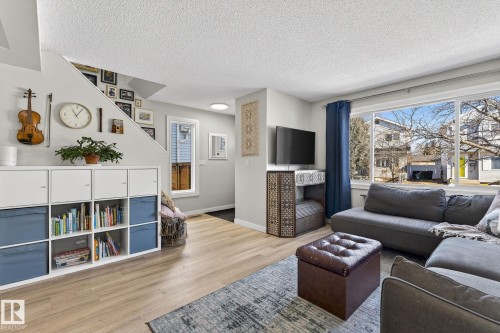 Living room featuring light-toned flooring, a large window with views of the exterior, and a white ceiling - 1873 151 Avenue, Edmonton, AB - Indoor Photo Showing Living Room
