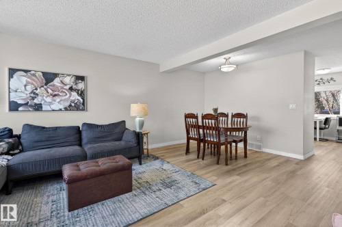 Inviting living and dining areas featuring light-toned flooring, neutral wall colors, and a ceiling light fixture in the dining space - 1873 151 Avenue, Edmonton, AB - Indoor Photo Showing Living Room
