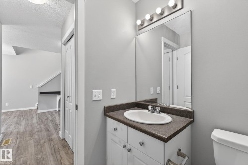 Bathroom featuring a white vanity with silver hardware, a white oval sink, and a dark countertop - 30 450 Hyndman Crescent, Edmonton, AB - Indoor Photo Showing Bathroom