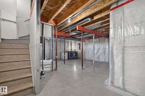 The property features an unfinished basement with exposed wooden joists and concrete flooring - 30 450 Hyndman Crescent, Edmonton, AB - Indoor Photo Showing Basement