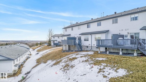 The property features a white exterior, a deck with railings, and an exterior stairway - 30 450 Hyndman Crescent, Edmonton, AB - Outdoor With Deck Patio Veranda