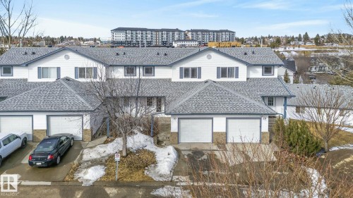 The property features a white exterior with blue shutters and a gray shingled roof - 30 450 Hyndman Crescent, Edmonton, AB - Outdoor