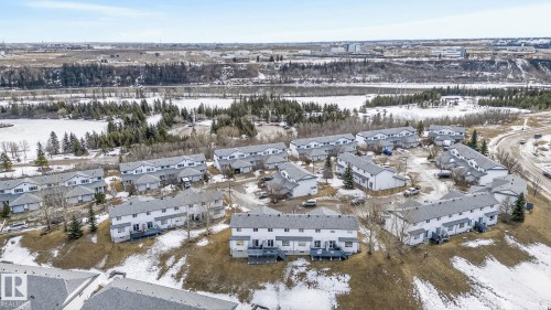 This property features a townhome community with views of natural scenery including a body of water and wooded areas - 30 450 Hyndman Crescent, Edmonton, AB - Outdoor With View