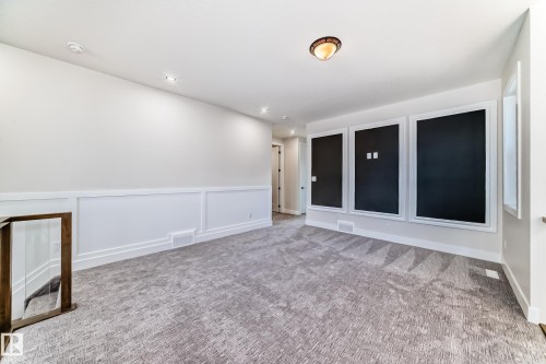 This versatile room features light-colored walls with wainscoting, recessed lighting, and a neutral-toned patterned carpet - 7665 Kimiwan Crescent, Edmonton, AB - Indoor Photo Showing Other Room