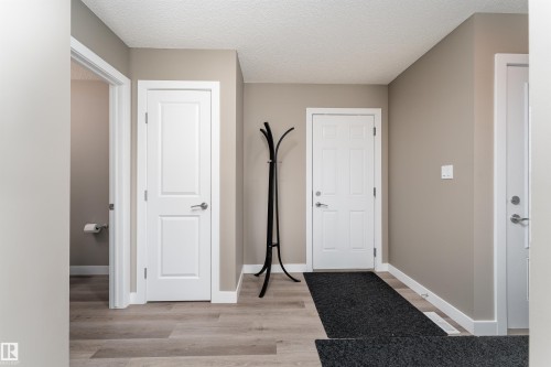Entryway featuring a textured ceiling and light wood-style floors - 1964 Kroetsch Crescent, Edmonton, AB - Indoor Photo Showing Other Room