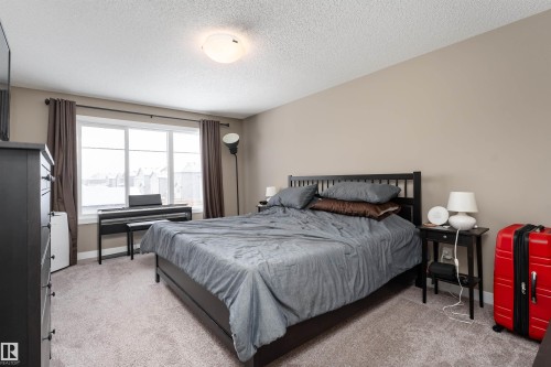 Bedroom with light colored carpet and a textured ceiling - 1964 Kroetsch Crescent, Edmonton, AB - Indoor Photo Showing Bedroom