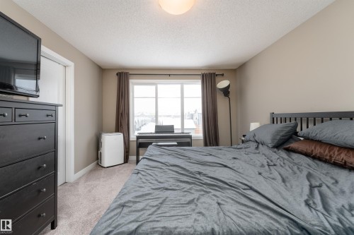 Bedroom featuring light carpet and a textured ceiling - 1964 Kroetsch Crescent, Edmonton, AB - Indoor Photo Showing Bedroom