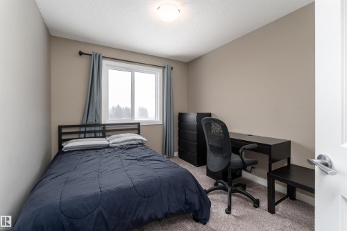 Bedroom with light carpet, a textured ceiling, and an office area - 1964 Kroetsch Crescent, Edmonton, AB - Indoor Photo Showing Bedroom