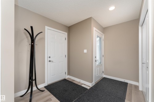Entryway featuring light wood finished floors and a textured ceiling - 1964 Kroetsch Crescent, Edmonton, AB - Indoor Photo Showing Other Room