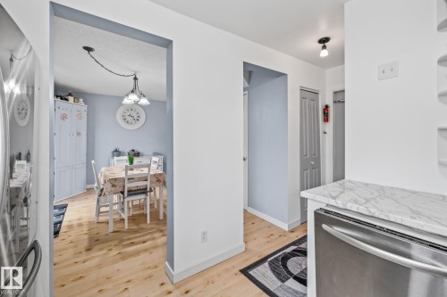 Dining area with light wood flooring, a decorative light fixture, and light blue wall accents - 10940 Beaumaris Road, Edmonton, AB - Indoor