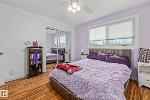 The property features wood flooring, a window with blinds, and a ceiling fan with integrated lighting - 10940 Beaumaris Road, Edmonton, AB - Indoor Photo Showing Bedroom
