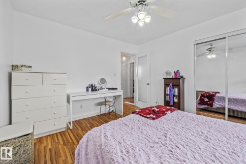 This room features hardwood flooring, white walls, and a ceiling fan with integrated lighting - 10940 Beaumaris Road, Edmonton, AB - Indoor Photo Showing Bedroom