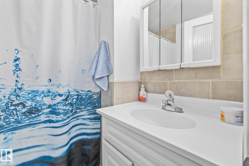 Bathroom featuring a vanity with a white countertop and a medicine cabinet with mirrored doors - 10940 Beaumaris Road, Edmonton, AB - Indoor Photo Showing Bathroom