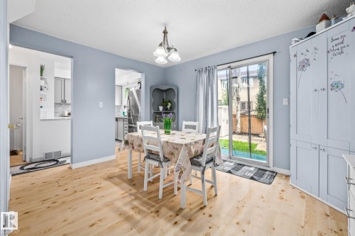 This dining area features light wood flooring and sliding glass doors that open to the exterior - 10940 Beaumaris Road, Edmonton, AB - Indoor Photo Showing Dining Room