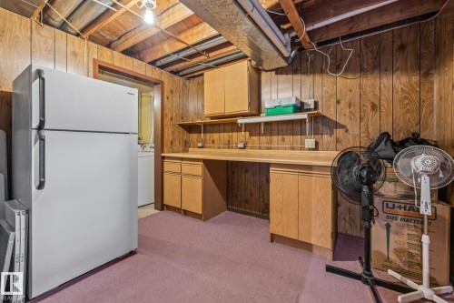This space features wood paneling, wood cabinets, and a workbench area - 10940 Beaumaris Road, Edmonton, AB - Indoor Photo Showing Basement
