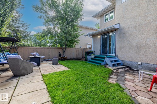The property features a private backyard with a patio area, a well-maintained lawn, and mature trees - 10940 Beaumaris Road, Edmonton, AB - Outdoor