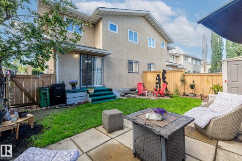 The property features a private backyard with a lawn, a paved patio area, and a wooden fence - 10940 Beaumaris Road, Edmonton, AB - Outdoor With Exterior