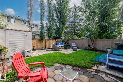 The property features a fenced backyard with a patio, lawn area, and mature trees - 10940 Beaumaris Road, Edmonton, AB - Outdoor