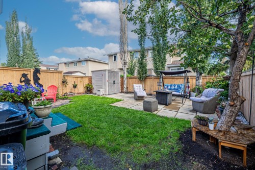 The property features a fenced yard with a lawn, a paved patio area, and a garden shed - 10940 Beaumaris Road, Edmonton, AB - Outdoor