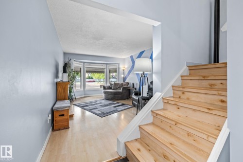 The property features light wood flooring and a staircase with light wood treads and white risers - 10940 Beaumaris Road, Edmonton, AB - Indoor