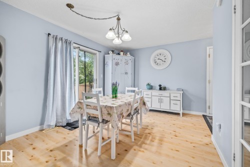 Dining area featuring light-colored flooring, a sliding glass door, and a ceiling-mounted light fixture - 10940 Beaumaris Road, Edmonton, AB - Indoor Photo Showing Dining Room