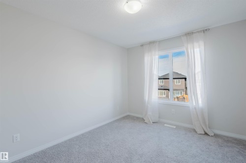 This room features light grey carpeting, white walls, and a window with white curtains - 2082 Price Landing, Edmonton, AB - Indoor Photo Showing Other Room