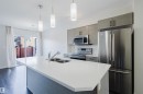 The kitchen features an island with a double sink, stainless steel appliances, and sleek cabinetry - 2082 Price Landing, Edmonton, AB  - Indoor Photo Showing Kitchen With Stainless Steel Kitchen With Double Sink With Upgraded Kitchen 
