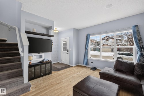 Living area featuring light-colored flooring, a large window, and light blue walls - 1522 Chapman Way, Edmonton, AB - Indoor