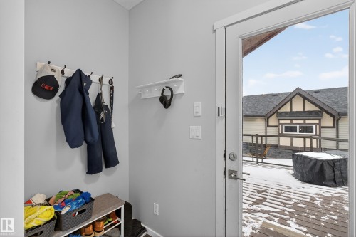The property features a private outdoor deck accessible via a white door, offering an view of the surrounding neighborhood - 1522 Chapman Way, Edmonton, AB - Indoor Photo Showing Other Room