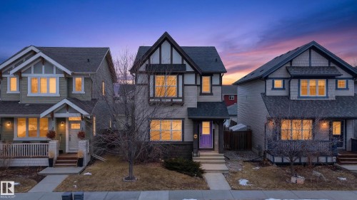 The property features a charming exterior with a gabled roof, decorative timber accents, and a distinctive purple front door - 1522 Chapman Way, Edmonton, AB - Outdoor With Facade